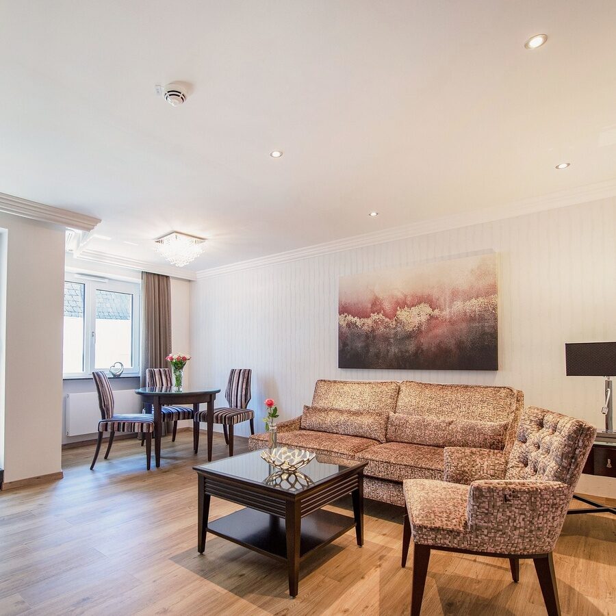 Der Wohnraum in einem Appartement der Kategorie 4 im Neubau des Hotels Residenz am Rosengarten bietet unter anderem einen Tisch mit Stühlen und eine Couch